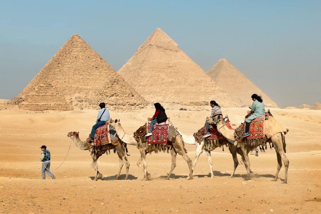 Four People Riding on Camels Across the Pyramids, Top Ten Wonders of the World 